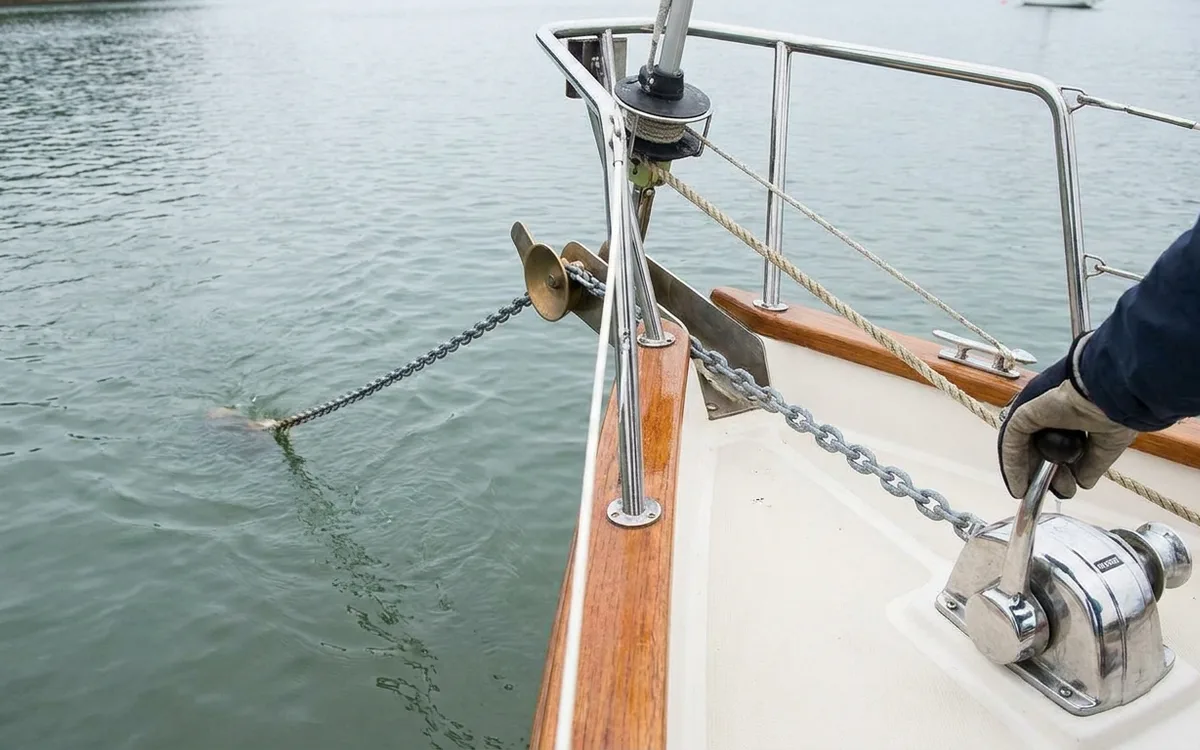 A boater gradually applies reverse thrust as the anchor rode straightens to set the anchor.