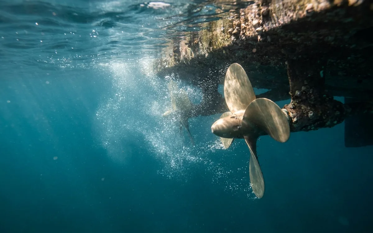 Underwater view of a boat propeller pushing water astern