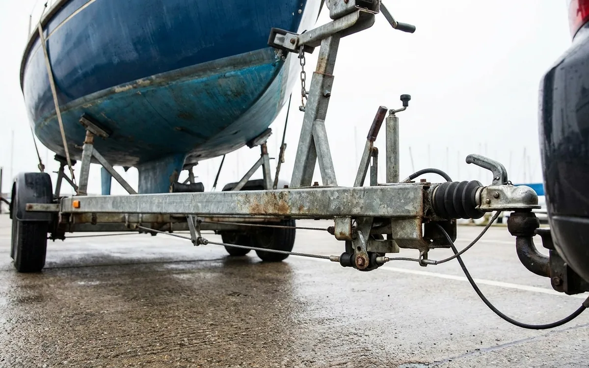 Close view of a boat trailer’s sliding overrun hitch and steel brake linkage.